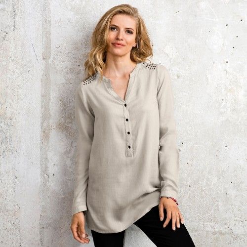 Une femme porte une blouse beige