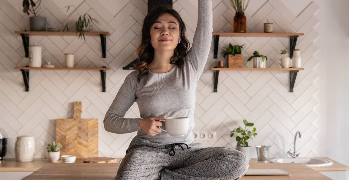 Fille pull gris qui tend le bras au ciel