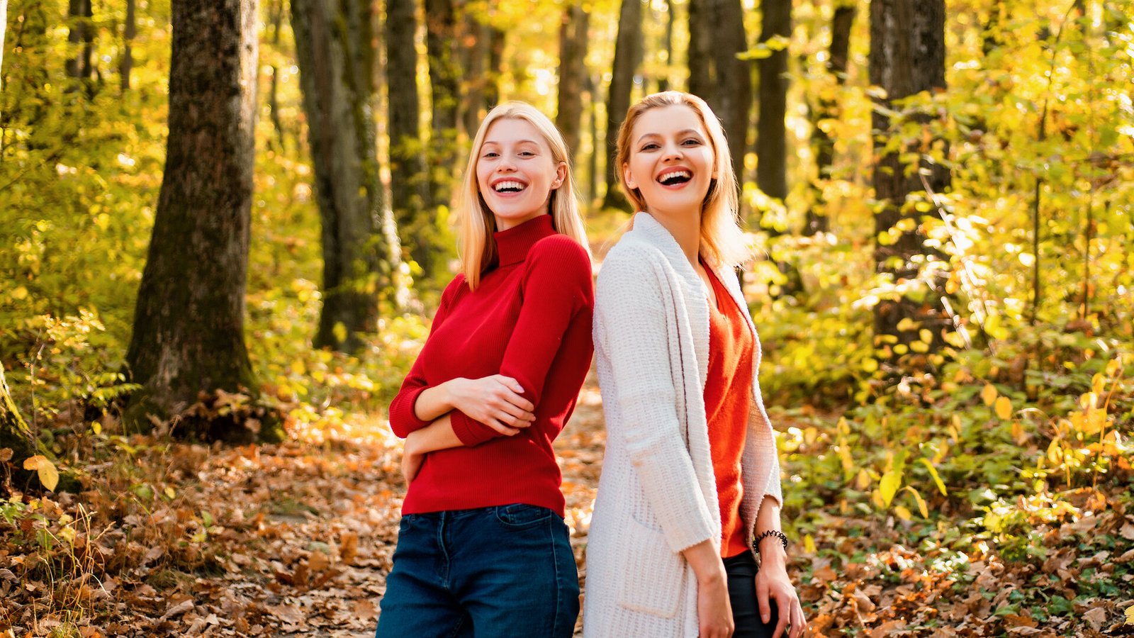 Deux amies rient lors d’une promenade dans un sous-bois aux couleurs d’automne